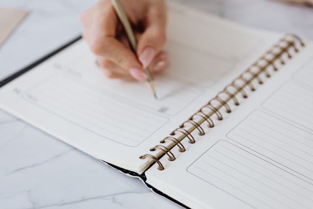 A Person Writing on a Notebook to learn a foreign language.