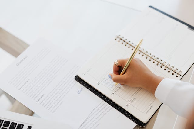 Person Writing on a Notebook