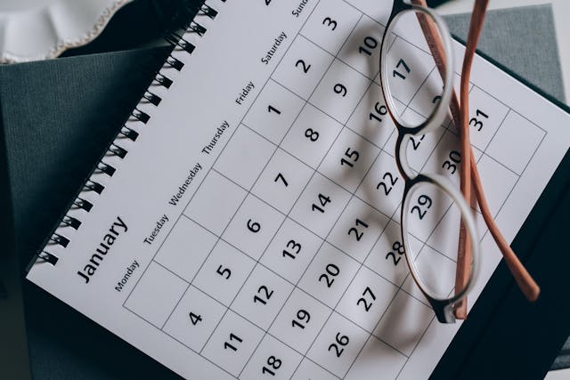 Brown-Framed Eyeglasses on a Calendar for language  learning journey tracking.