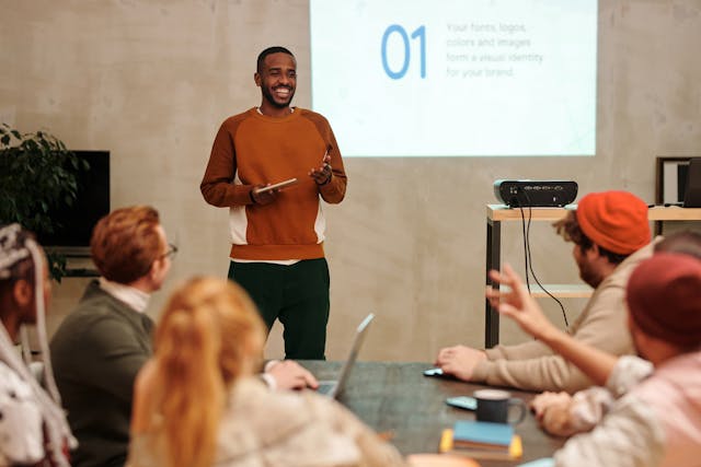 Man in Sweatshirt In Front of People speaking his partner's native language